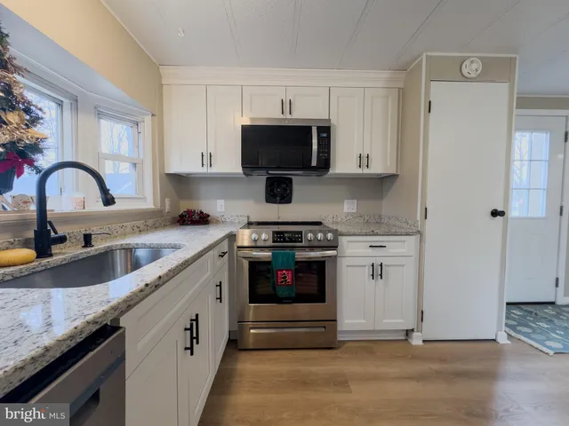 a kitchen with stainless steel appliances granite countertop a stove and a sink