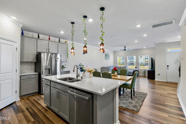 a kitchen with stainless steel appliances granite countertop a sink refrigerator and cabinets