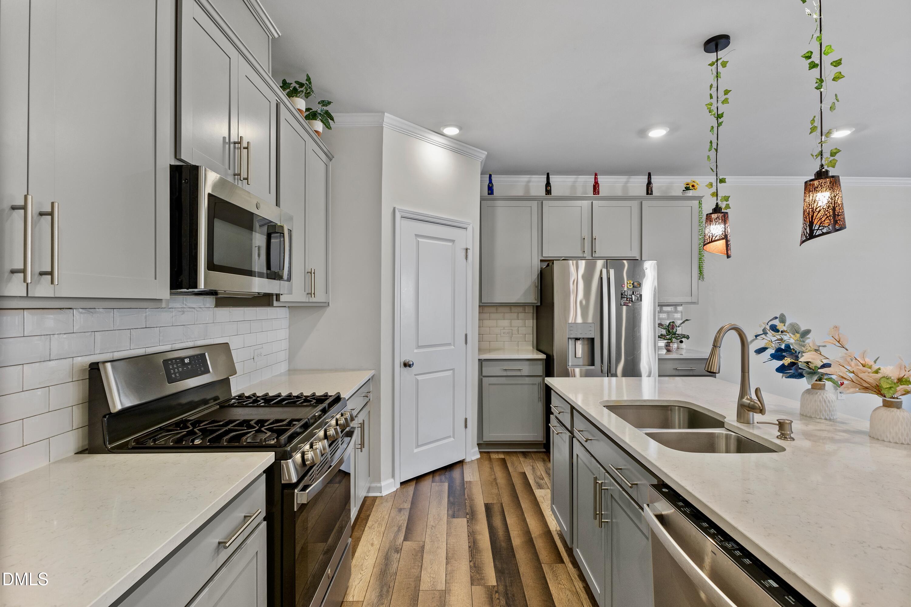1811 Aspen River Lane Apex, NC 27502 - Photo 16 of 53 a kitchen with stainless steel appliances a sink stove and refrigerator