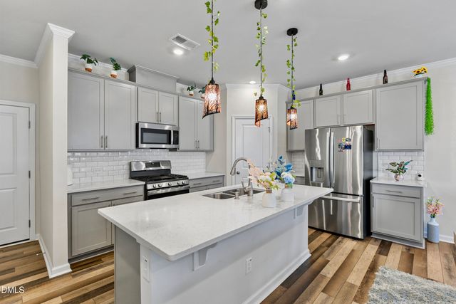 a kitchen with refrigerator cabinets and wooden floor