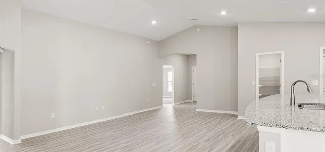 a view of a kitchen with a sink and wooden floor