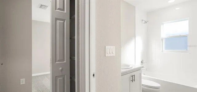 a bathroom with a sink a toilet and a window