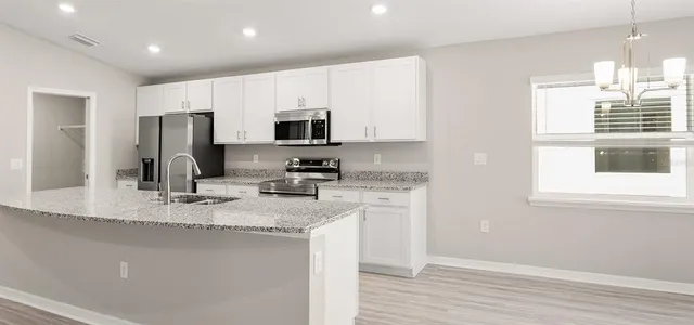 a kitchen with stainless steel appliances granite countertop a sink refrigerator and microwave