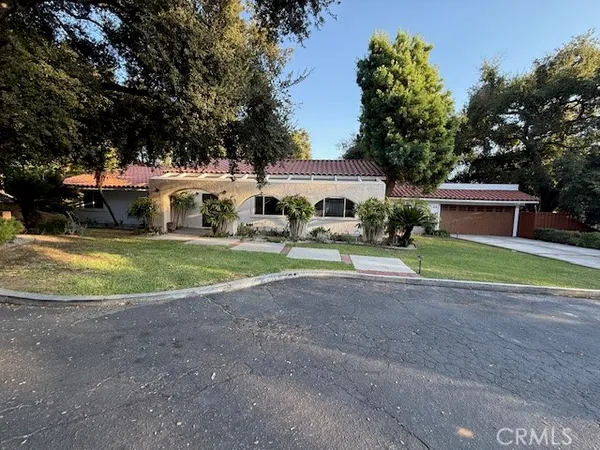 a view of a house with a big yard and large trees