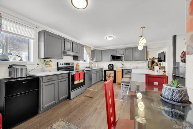 a kitchen with stainless steel appliances kitchen island granite countertop a refrigerator stove top oven and sink
