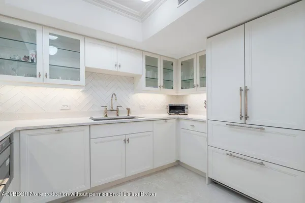 a kitchen with white cabinets and sink