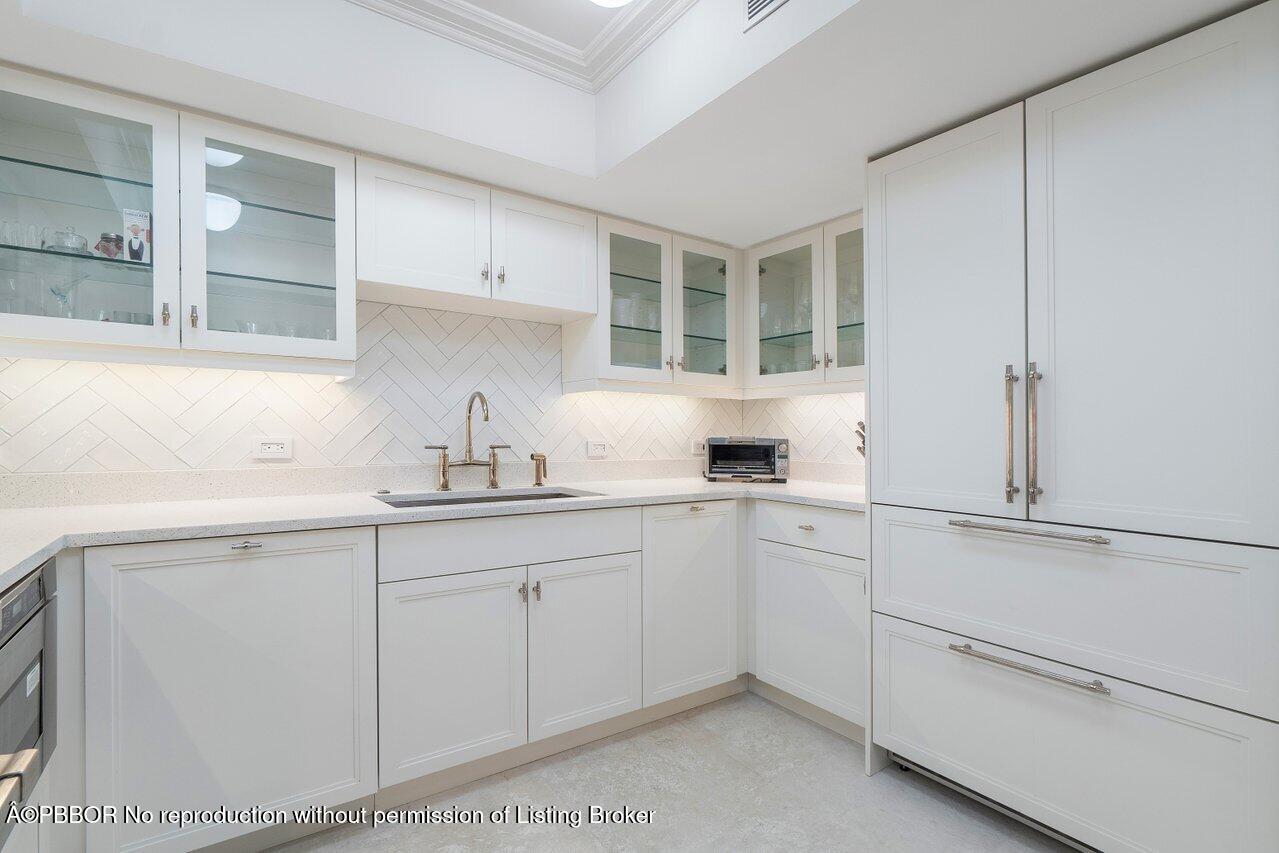 130 Sunrise Avenue, Unit 616 Palm Beach, FL 33480 - Photo 11 of 34 a kitchen with white cabinets and sink