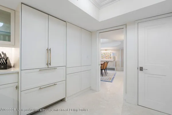 a hallway with white doors and chandelier
