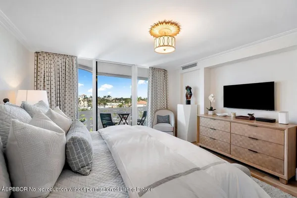 a large bedroom with a bed and a flat tv screen on dresser