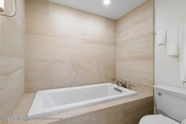 a bath tub sitting next to a white toilet