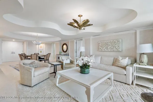 a living room with furniture a chandelier and a potted plant