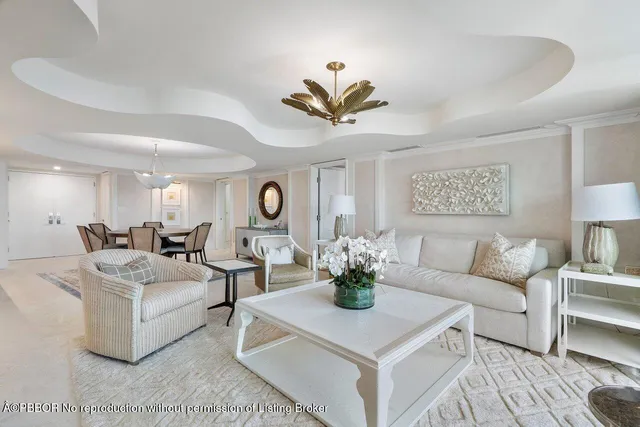 a living room with furniture a chandelier and a potted plant