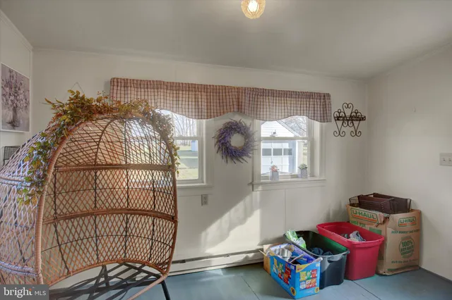a living room with a baby crib furniture and a window