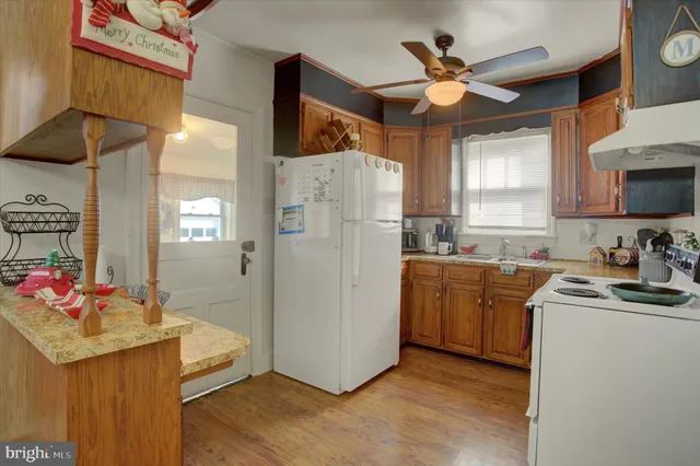 a kitchen with granite countertop a sink appliances cabinets and a counter top space