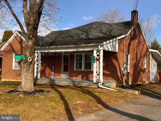 a view of a house with large windows and a tree