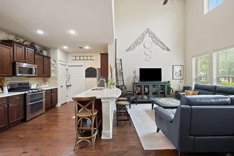 a living room with furniture a flat screen tv and kitchen view