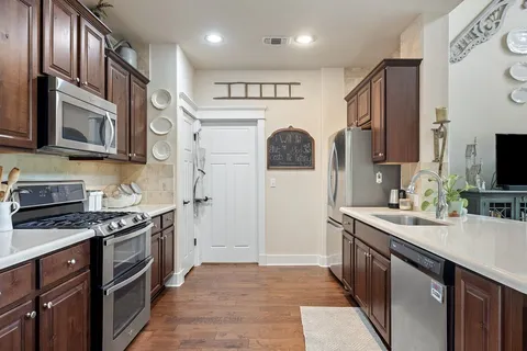a kitchen with stainless steel appliances granite countertop a sink stove and cabinets