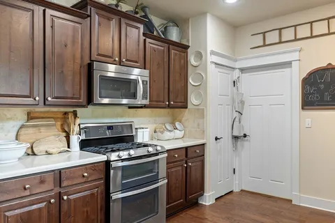 a kitchen with stainless steel appliances white cabinets and a stove top oven