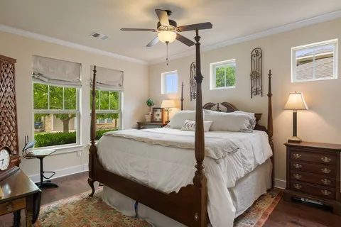 a bedroom with a bed a chandelier and a window
