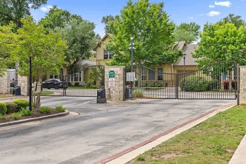 a front view of a house with a garden and trees