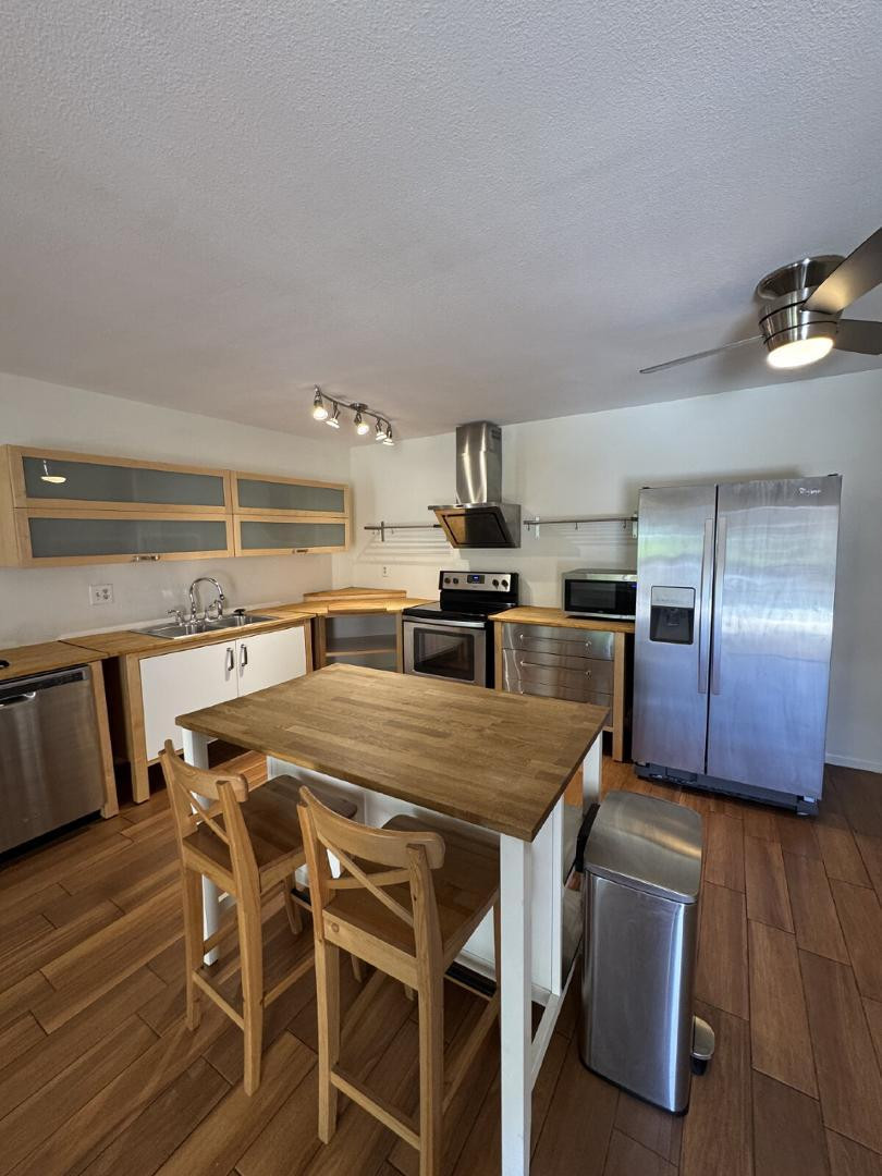 a kitchen with kitchen island a counter space a sink appliances and cabinets