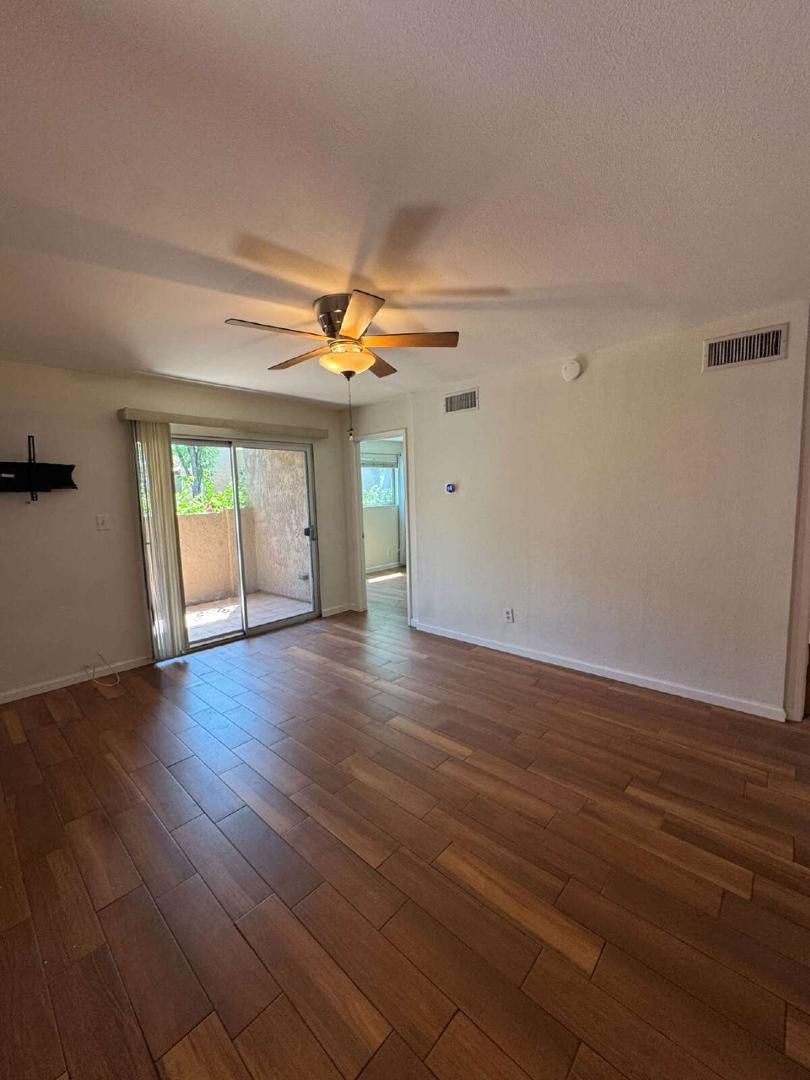 5525 East Thomas Road, Unit F1 Phoenix, AZ 85018 - Photo 4 of 14 a view of an empty room with window and wooden floor