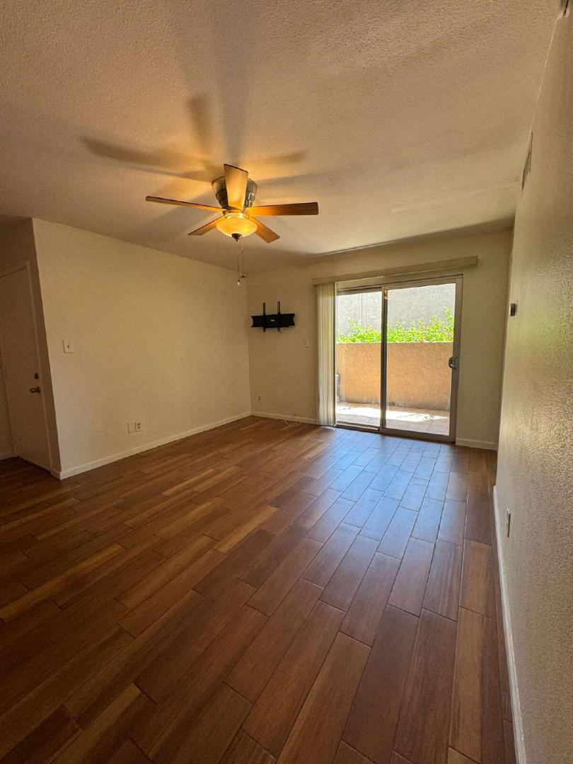 5525 East Thomas Road, Unit F1 Phoenix, AZ 85018 - Photo 5 of 14 a view of empty room with wooden floor and fan