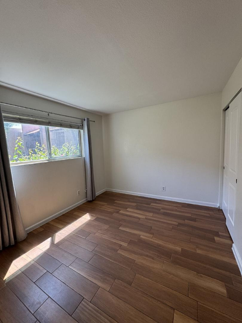 5525 East Thomas Road, Unit F1 Phoenix, AZ 85018 - Photo 6 of 14 an empty room with wooden floor and windows