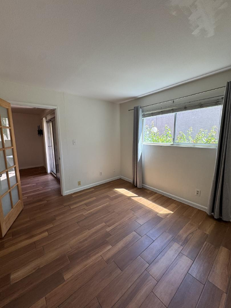 5525 East Thomas Road, Unit F1 Phoenix, AZ 85018 - Photo 7 of 14 an empty room with wooden floor and windows
