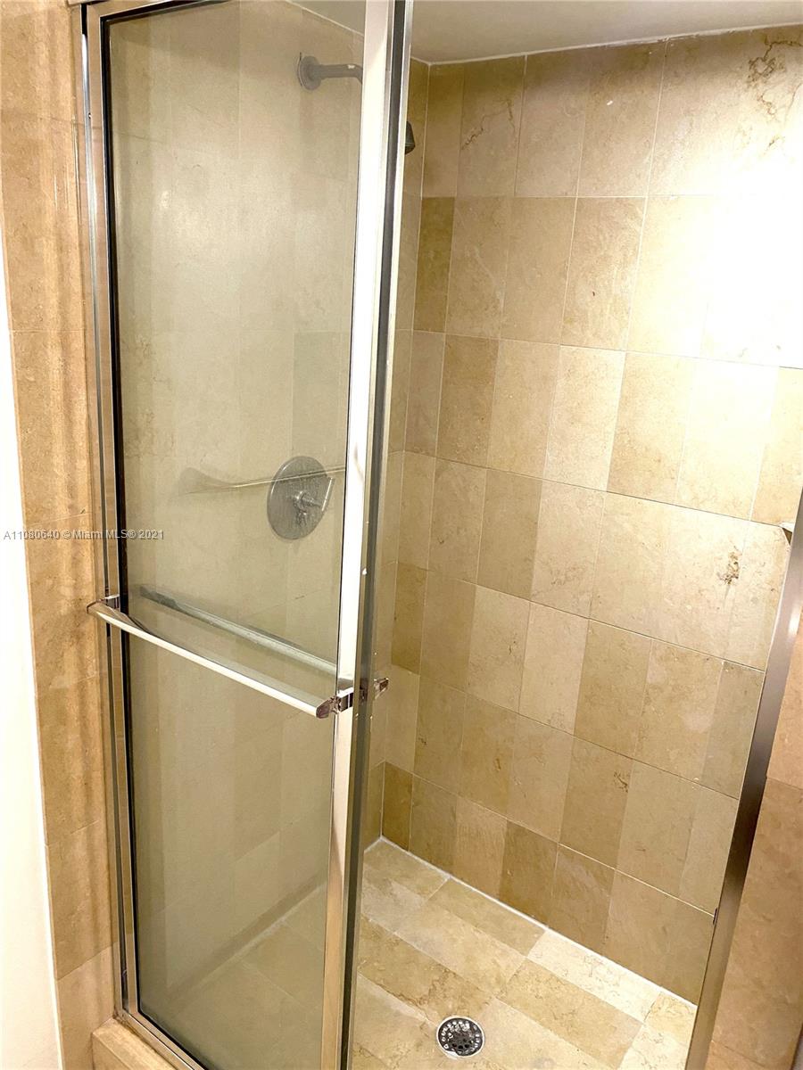 9499 Collins Avenue, Unit 309 Surfside, FL 33154 - Photo 12 of 16 a bathroom with a glass shower door