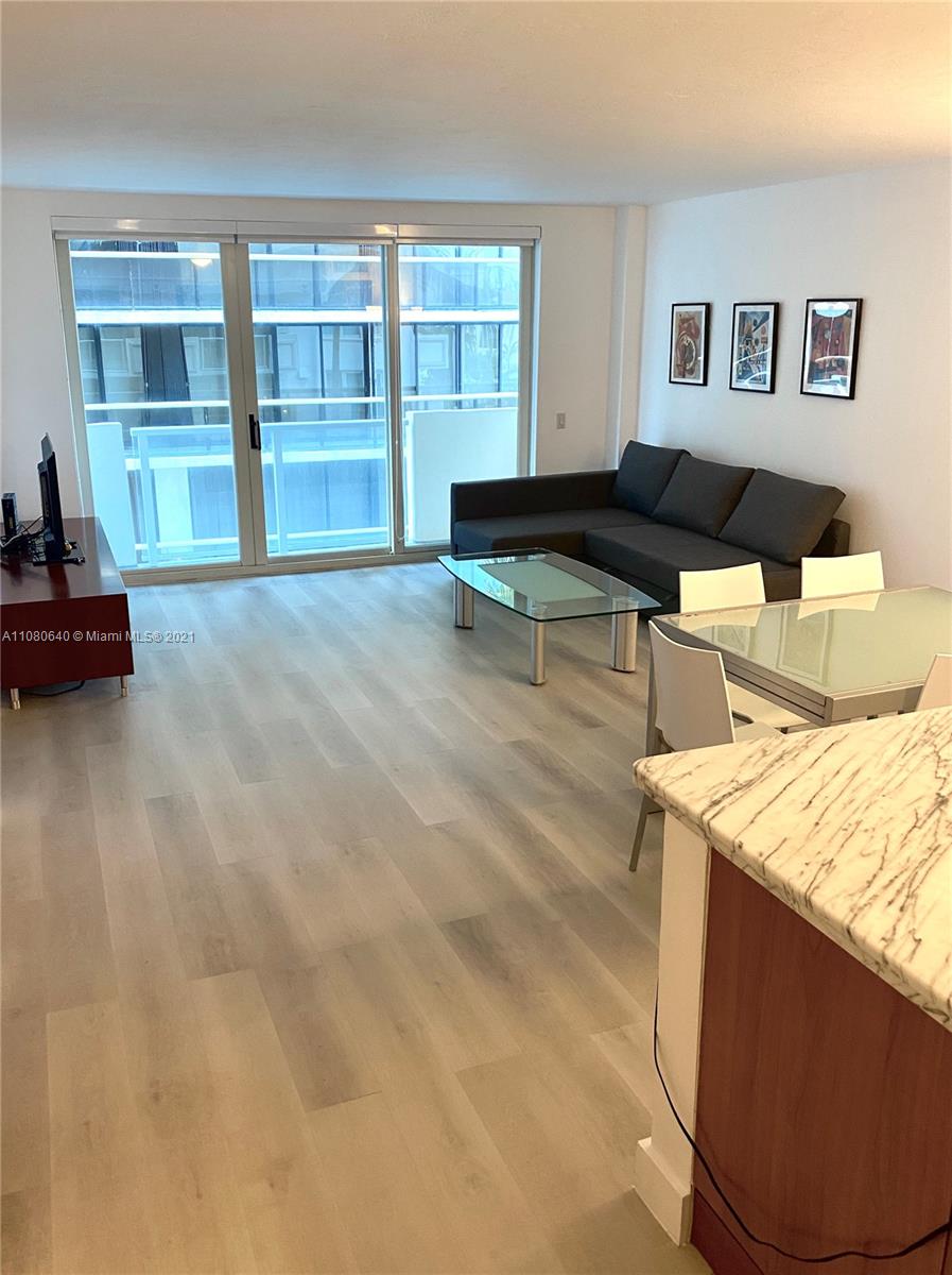 9499 Collins Avenue, Unit 309 Surfside, FL 33154 - Photo 3 of 16 a living room with a couch and a table