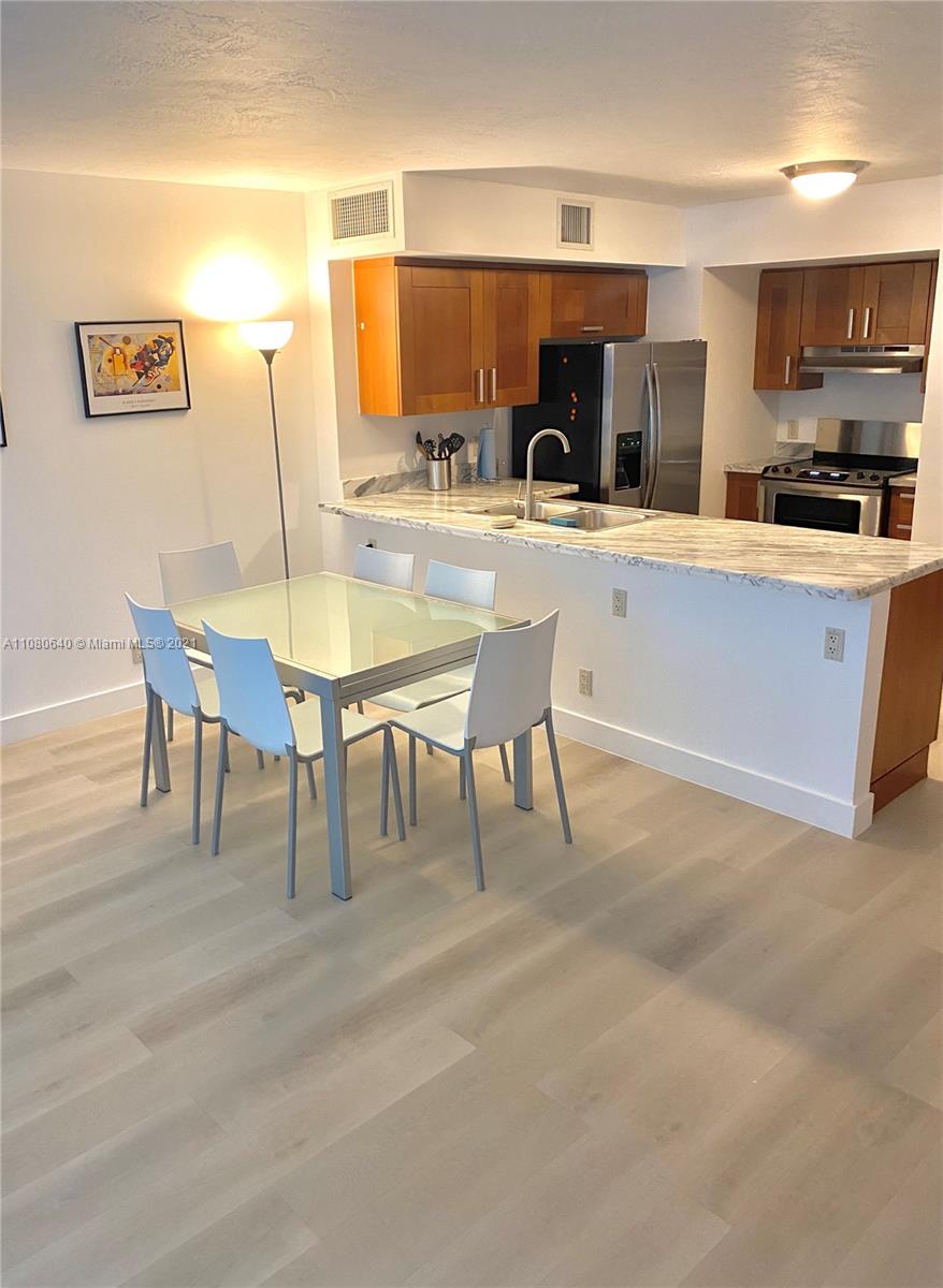9499 Collins Avenue, Unit 309 Surfside, FL 33154 - Photo 4 of 16 a living room with stainless steel appliances kitchen island granite countertop furniture and a kitchen view