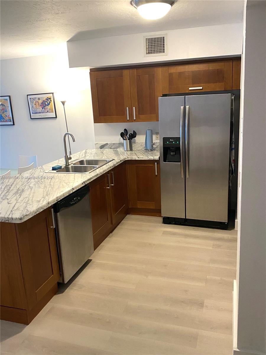 9499 Collins Avenue, Unit 309 Surfside, FL 33154 - Photo 6 of 16 a kitchen with stainless steel appliances granite countertop a refrigerator and a sink