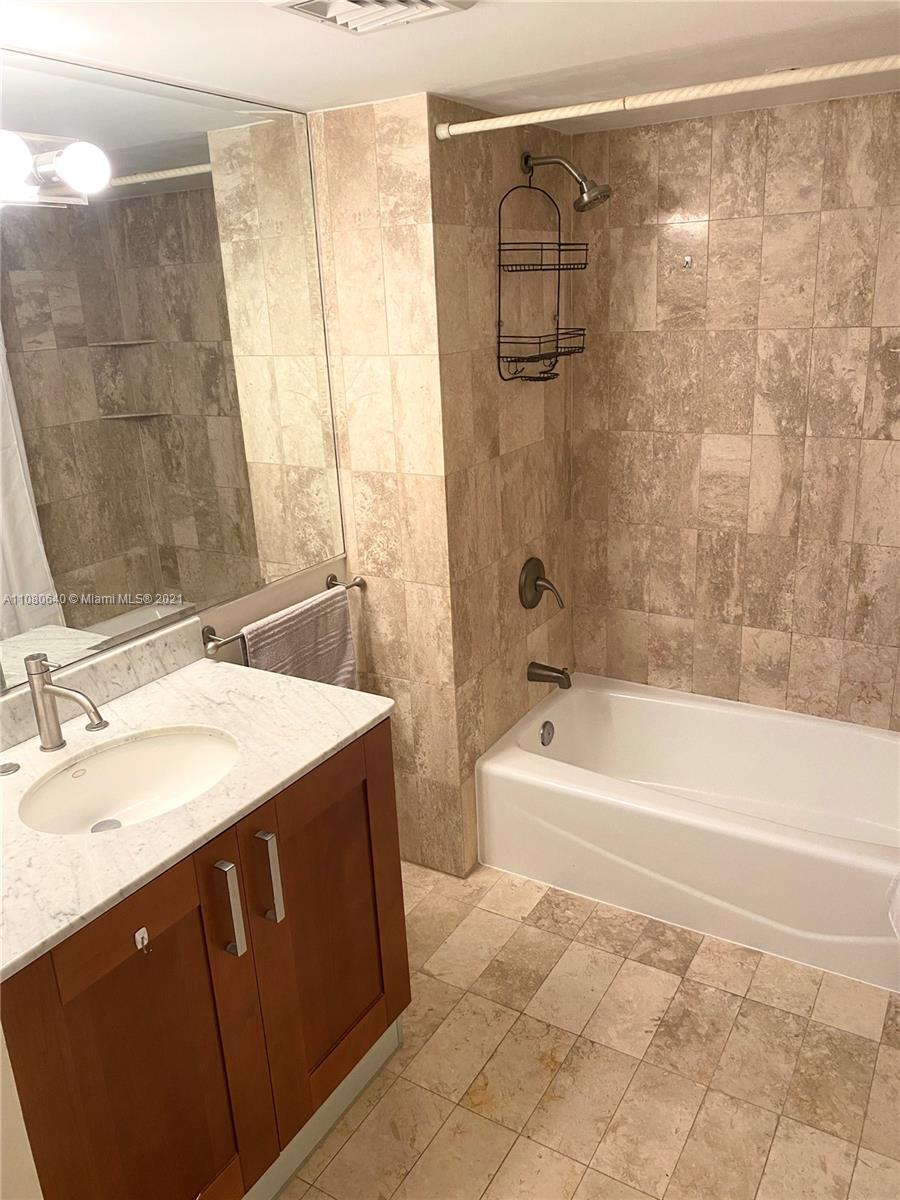 9499 Collins Avenue, Unit 309 Surfside, FL 33154 - Photo 7 of 16 a bathroom with a sink and a mirror