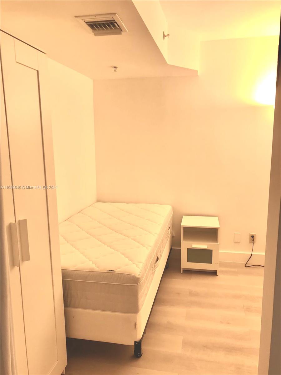 9499 Collins Avenue, Unit 309 Surfside, FL 33154 - Photo 9 of 16 a bedroom with a bed and a cabinets