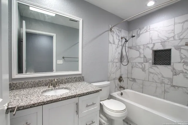 a view of a room with a ceiling fan and a window