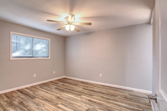 a view of a room with wooden floor and a ceiling fan