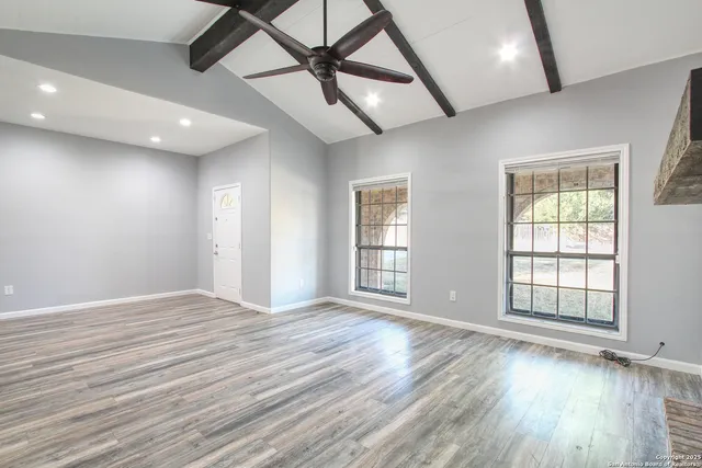 a view of empty room with wooden floor