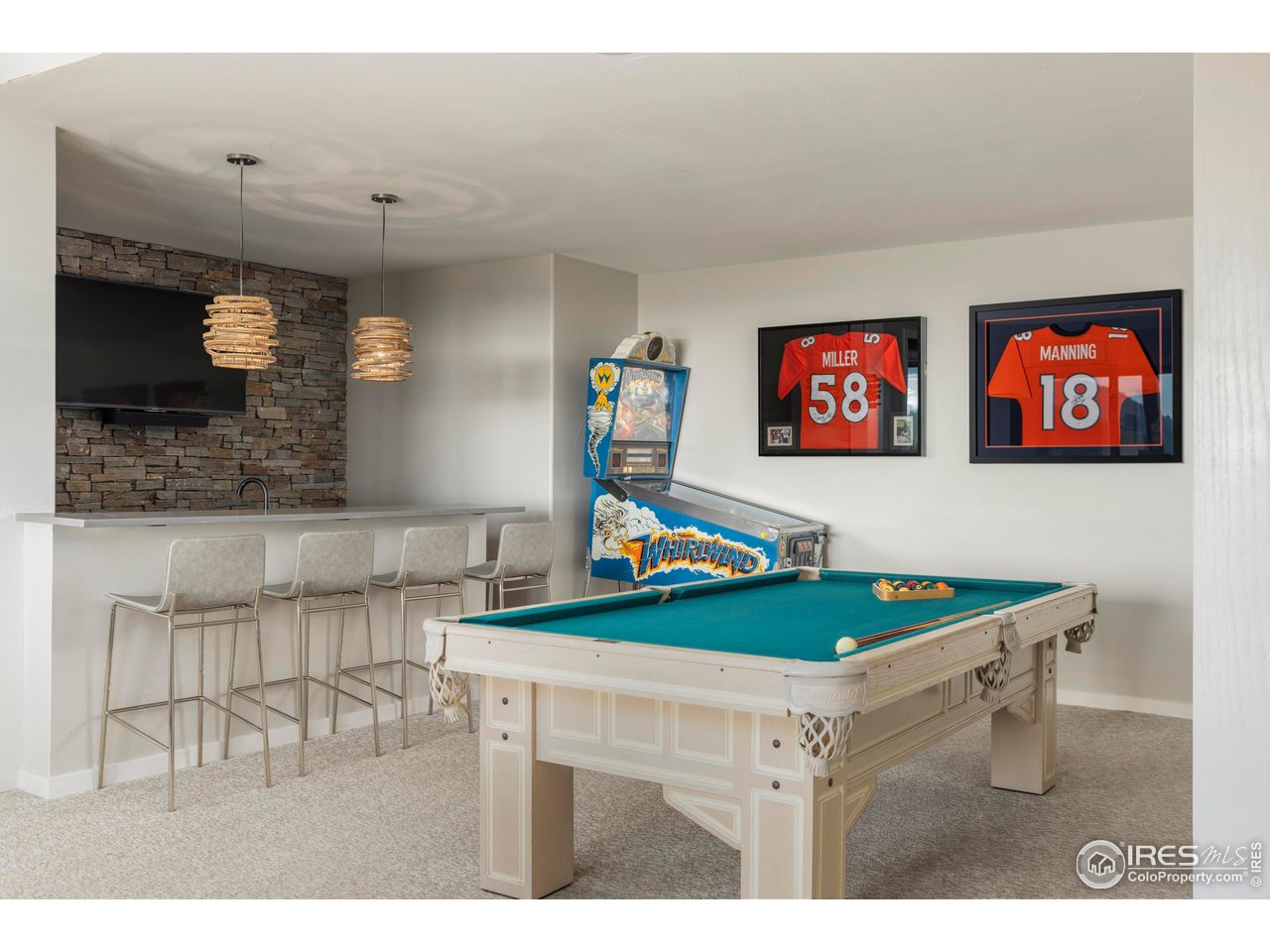 150 Valley View Way Boulder, CO 80304 - Photo 30 of 36 Downstairs, a spacious recreation room expands possibilities for movie nights or game days, while the adjacent bar with stone accent wall creates a complete entertaining zone.