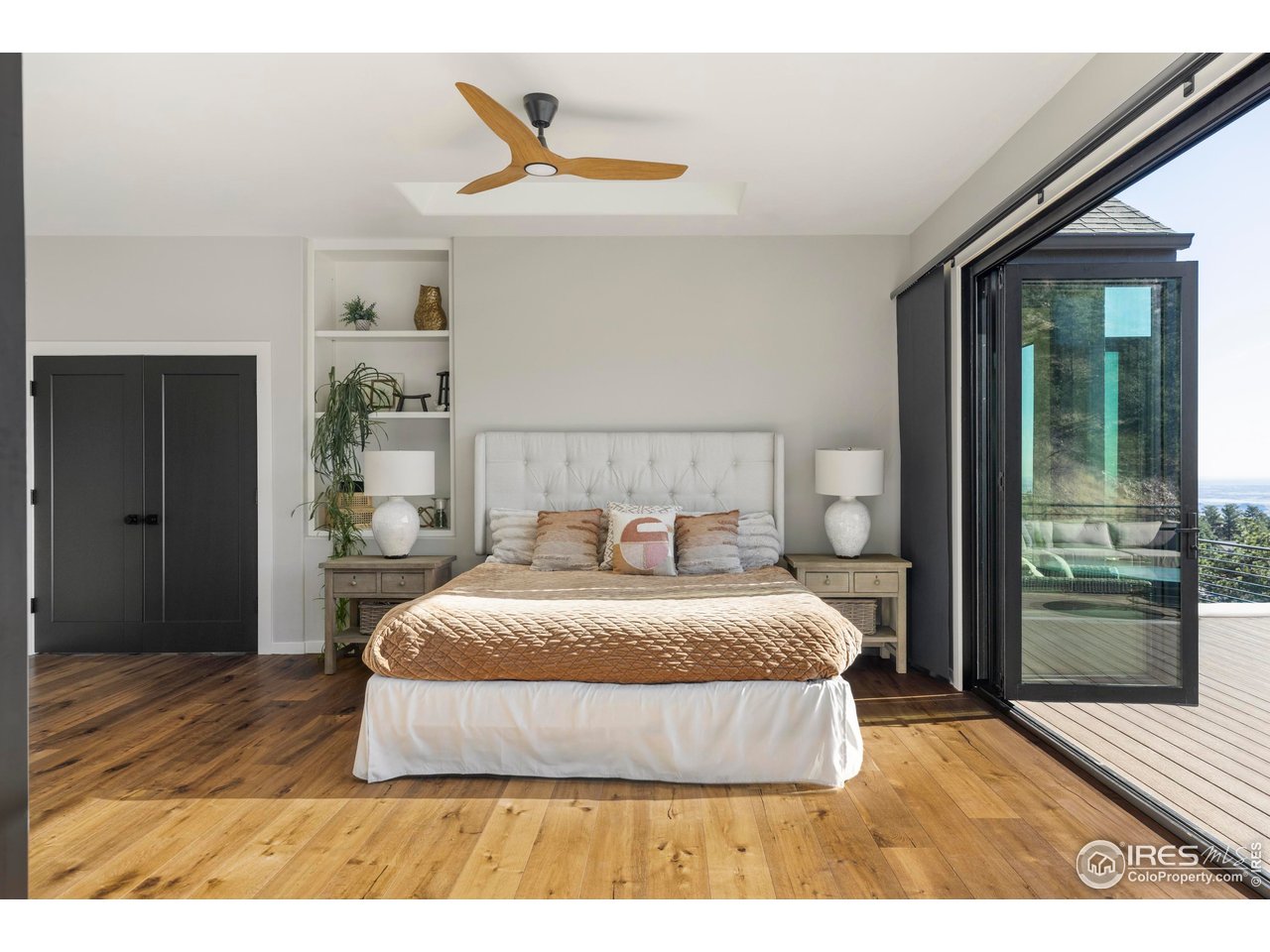 150 Valley View Way Boulder, CO 80304 - Photo 10 of 36 The main-floor primary suite offers an ideal layout for long-term livability, featuring hardwood floors, wraparound glass doors, and direct deck access where the views take center stage.