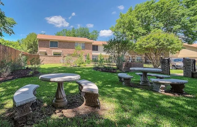 a view of a table and chairs in backyard of the house