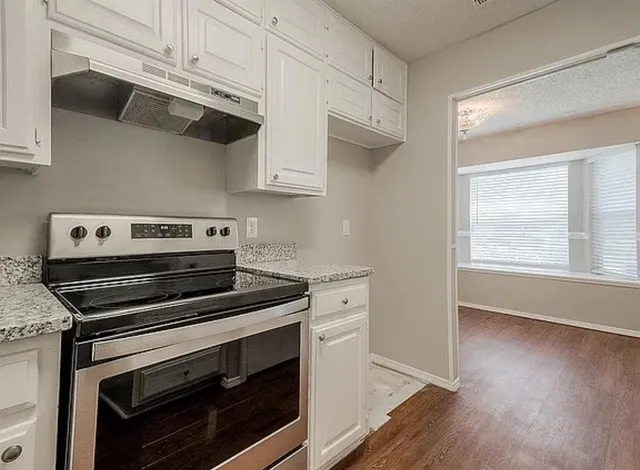 a kitchen with cabinets and steel appliances