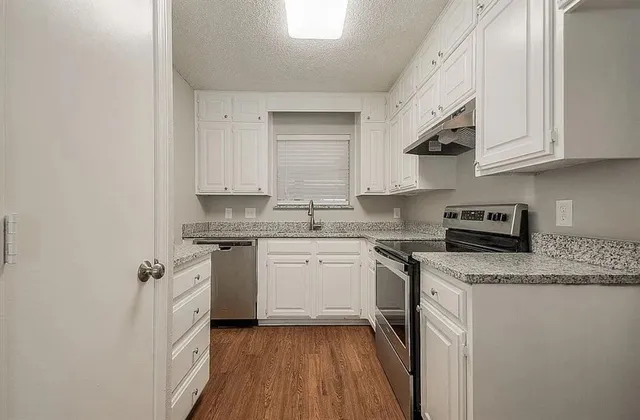a kitchen with stainless steel appliances granite countertop a sink stove and cabinets