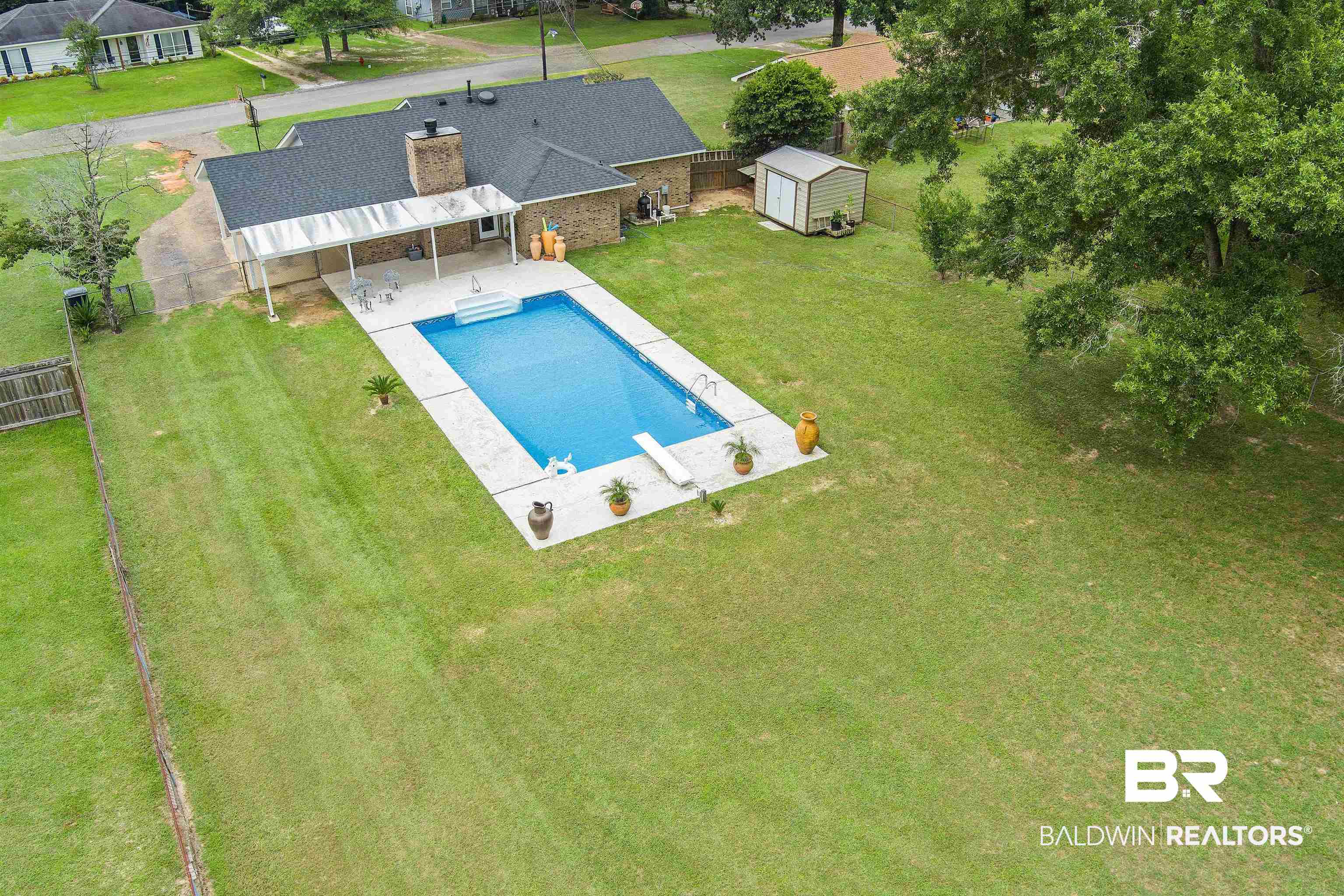 2000 Campfire Drive Semmes, AL 36575 - Photo 21 of 26 View of pool with a storage unit, a diving board, and a lawn