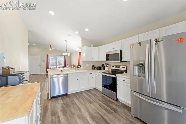 a kitchen with granite countertop a refrigerator stove top oven and sink