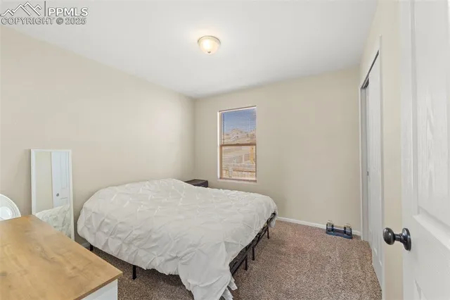 a bedroom with two beds and large window