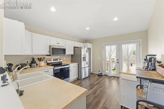 a kitchen with sink a refrigerator and wooden cabinets