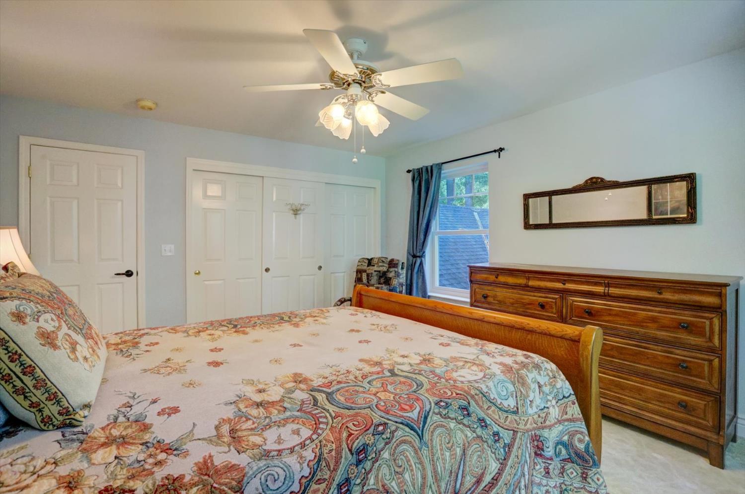 19793 Scotts Flat Road Nevada City, CA 95959 - Photo 32 of 50 a bedroom with a bed and a chandelier