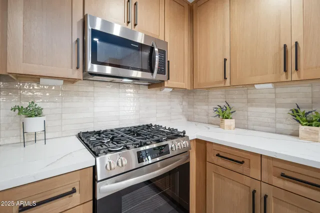 a kitchen with stainless steel appliances white cabinets and a stove top oven