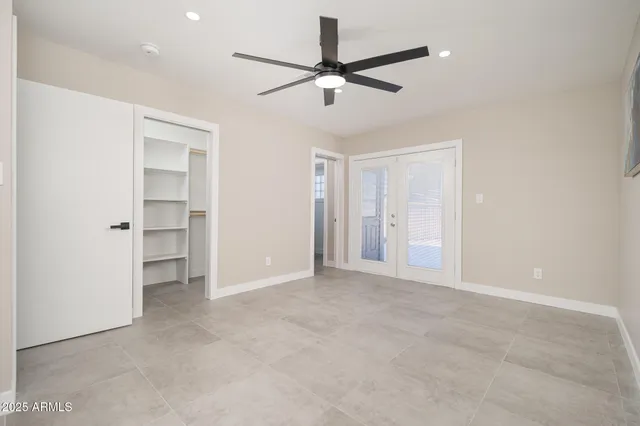 a view of an empty room with a ceiling fan
